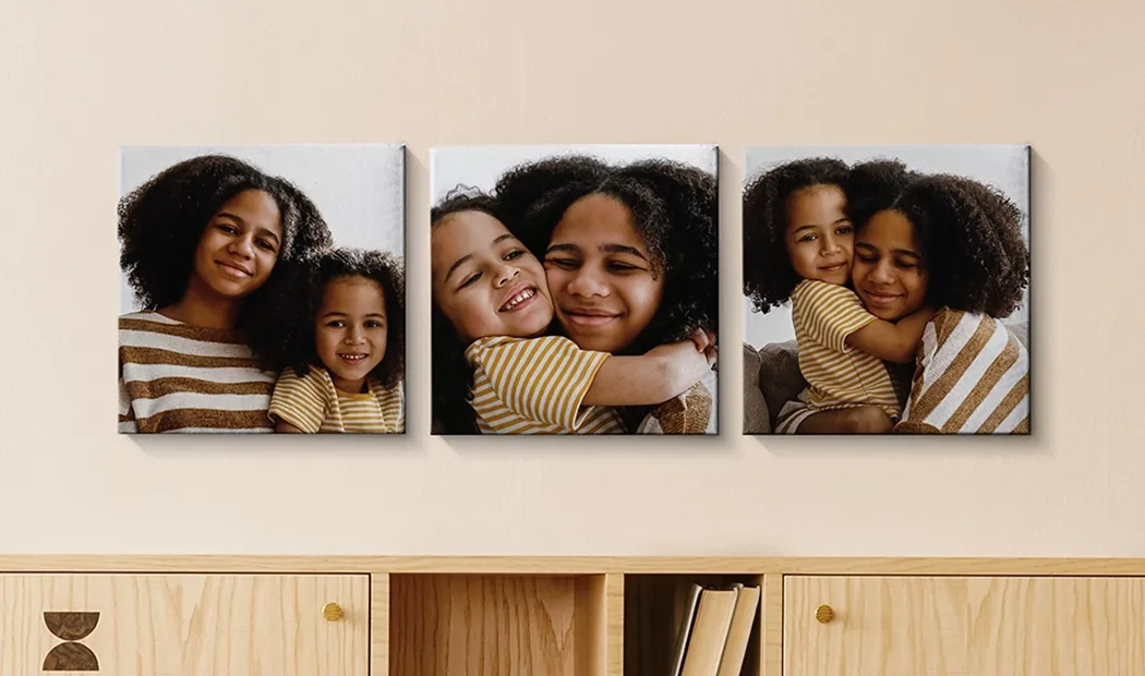 Paneles de Exhibición de Lienzos Fotográficos de Printerpix|Paneles de Lienzo|Hombre y mujer colocando un lienzo fotográfico con una foto de vacaciones|Mujer colocando tres lienzos fotográficos familiares en blanco y negro|Mamá y cuatro niños pequeños sentados en el sofá frente a cuatro lienzos fotográficos|Pareja frente a una pared azul con nueve lienzos fotográficos cuadrados|||||